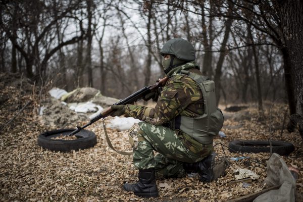 Một binh sĩ Ukraine trong tư thế sẵn sàng nổ súng từ vị trí của anh bên cạnh cây cầu bắc qua sông Siverskiy Donets, bị hư hại do vụ nổ trong cuộc giao tranh giữa phiến quân thân Nga và lực lượng chính phủ Ukraine gần ngôi làng Trehizbenka, vùng Luhansk, miền đông Ukraine, vào tháng 11/2014. (Ảnh: Evgeniy Maloletka/AP Photo)