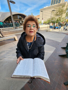 Bà Lydia ở Quận Maricopa đọc Kinh thánh trong lúc chờ đợi để vào trung tâm hội nghị của hội đồng giám sát quận, ở Phoenix hôm 28/11/2022. (Ảnh: Allan Stein/The Epoch Times)