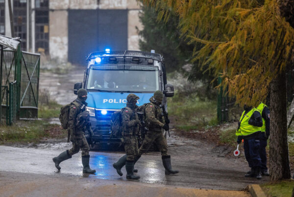 Hôm 17/11/2022, các binh sĩ Ba Lan đi bộ qua trạm kiểm soát của cảnh sát bên cạnh địa điểm xảy ra vụ tấn công bằng hỏa tiễn làm thiệt mạng hai người đàn ông ở ngôi làng Przewodow, miền đông Ba Lan, gần biên giới với Ukraine đang bị tàn phá bởi chiến tranh hôm 15/11/2022. (Ảnh: Wojtek Radwanksi and Damien Simonart/AFP qua Getty Images)