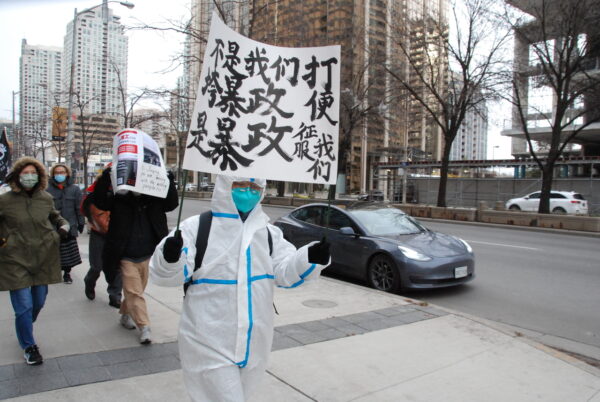 Một người biểu tình ở Toronto cầm tấm biển ghi “Hoặc là chúng ta đánh bại chế độ chuyên chế, hoặc là chế độ chuyên chế chinh phục chúng ta” ở Toronto hôm 19/11/2022. Một nhóm gồm các sinh viên Trung Quốc và những người bất đồng chính kiến ​​phản đối chính sách zero COVID của Bắc Kinh đã tổ chức một cuộc biểu tình kêu gọi chấm dứt chế độ cộng sản Trung Quốc. (Ảnh: Michelle Hu/The Epoch Times)