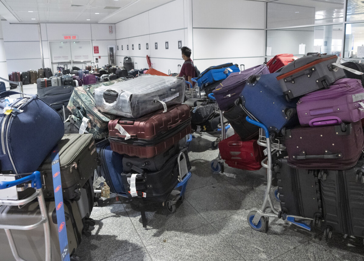 Một hành khách tìm hành lý của mình trong đống hành lý không có người nhận tại phi trường Pierre Elliott Trudeau ở Montreal hôm 29/06/2022. (Ảnh: Ryan Remiorz/The Canadian Press)