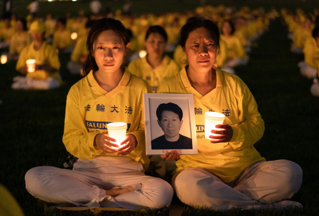 Con gái Lý Tiểu Hoa (Li Xiaohua) và mẹ cô là Cư Thụy Hồng (Ju Reihjong) tham dự buổi thắp nến tưởng niệm để tưởng nhớ các nạn nhân trong cuộc bức hại Pháp Luân Công kéo dài 23 năm ở Trung Quốc, được tổ chức tại Đài tưởng niệm Washington hôm 21/07/2022. Bà Cư cầm di ảnh của chồng bà và cũng là cha của cô Lý, ông Lý Đức Long (Li Delong), người đã thiệt mạng trong cuộc bức hại. (Ảnh: Samira Bouaou/The Epoch Times)