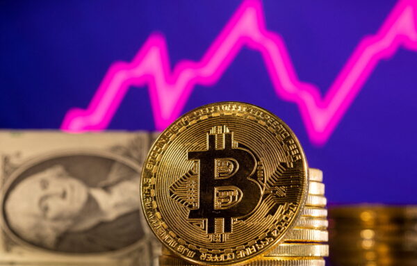 Một đồng token đại diện cho mã kim Bitcoin được đặt phía trước biểu đồ chứng khoán và tiền USD trong hình minh họa chụp hôm 24/01/2022 này. (Ảnh: Reuters/Dado Ruvic/Ảnh tư liệu)
