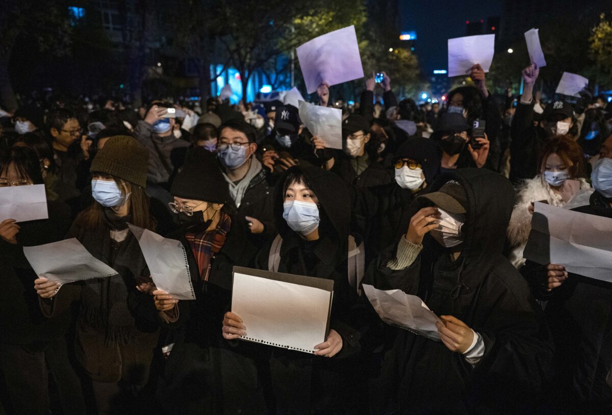 Những người biểu tình ở Bắc Kinh giơ cao các tờ giấy trắng để phản đối sự kiểm duyệt và các biện pháp zero COVID nghiêm ngặt của Trung Quốc, hôm 27/11/2022. (Ảnh: Kevin Frayer/Getty Images)