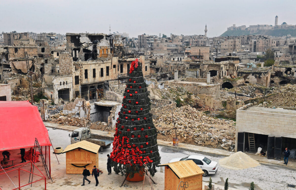 Các công nhân dựng một cây thông Noel ở Quảng trường Al-Hatab, một trong những quảng trường lâu đời nhất của Syria, ở phía bắc thành phố Aleppo hôm 12/12/2022. (Ảnh: AFP qua Getty Images)