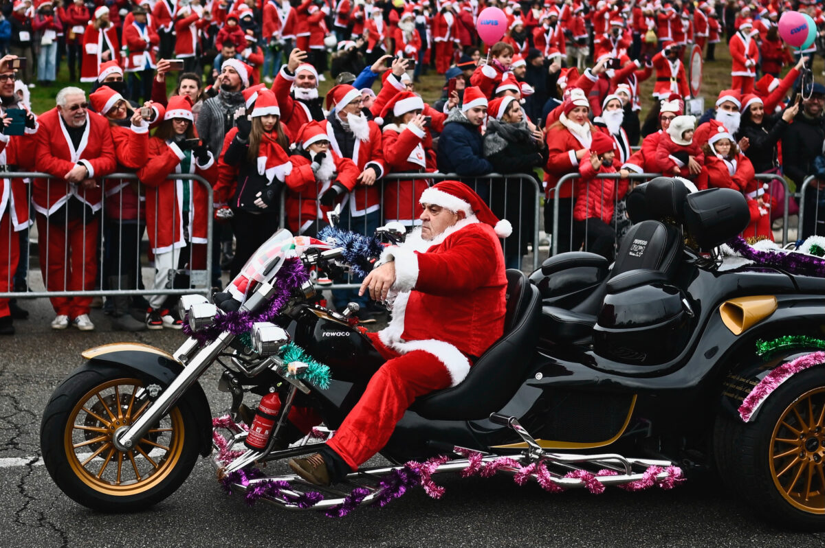 Một người đàn ông hóa trang thành ông già Noel lái xe máy của mình trong cuộc tập hợp từ thiện “Papa Noel” lần thứ 12 của ông già Noel ở Turin, Ý, hôm 04/12/2022, để gây quỹ cho một cơ sở chăm sóc y tế nhi khoa. (Ảnh: Marco Bertorello/AFP qua Getty Images)