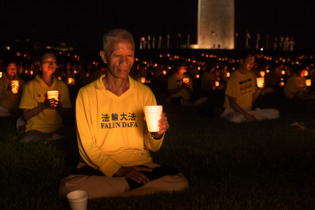 Các học viên Pháp Luân Đại Pháp (còn gọi là Pháp Luân Công) tổ chức một buổi thắp nến tưởng niệm để kỷ niệm 16 năm các bạn đồng môn của họ phải đối mặt với cuộc bức hại ở Trung Quốc, gần Đài tưởng niệm Washington vào ngày 16/07/2015. (Ảnh: Petr Svab/The Epoch Times)