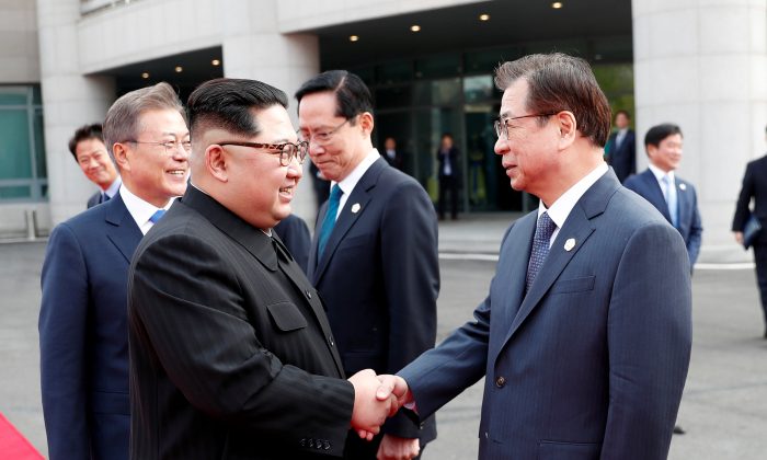 Lãnh đạo Bắc Hàn Kim Jong Un (phải) bắt tay với ông Suh-hoon, Giám đốc Cơ quan Tình báo Quốc gia (NIS) của Nam Hàn tại làng đình chiến Panmunjom bên trong khu phi quân sự ngăn cách hai miền Bắc-Nam vào ngày 27/04/2018. (Ảnh: Kho báo chí Hội nghị thượng đỉnh Bắc-Nam Hàn qua Reuters)