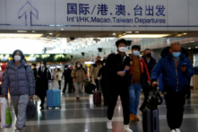 Các du khách xách hành lý đi bộ tại Phi trường Quốc tế Thủ đô Bắc Kinh, trong bối cảnh dịch COVID-19 bùng phát ở Bắc Kinh, Trung Quốc, hôm 27/12/2022. (Ảnh: Tingshu Wang/Reuters)