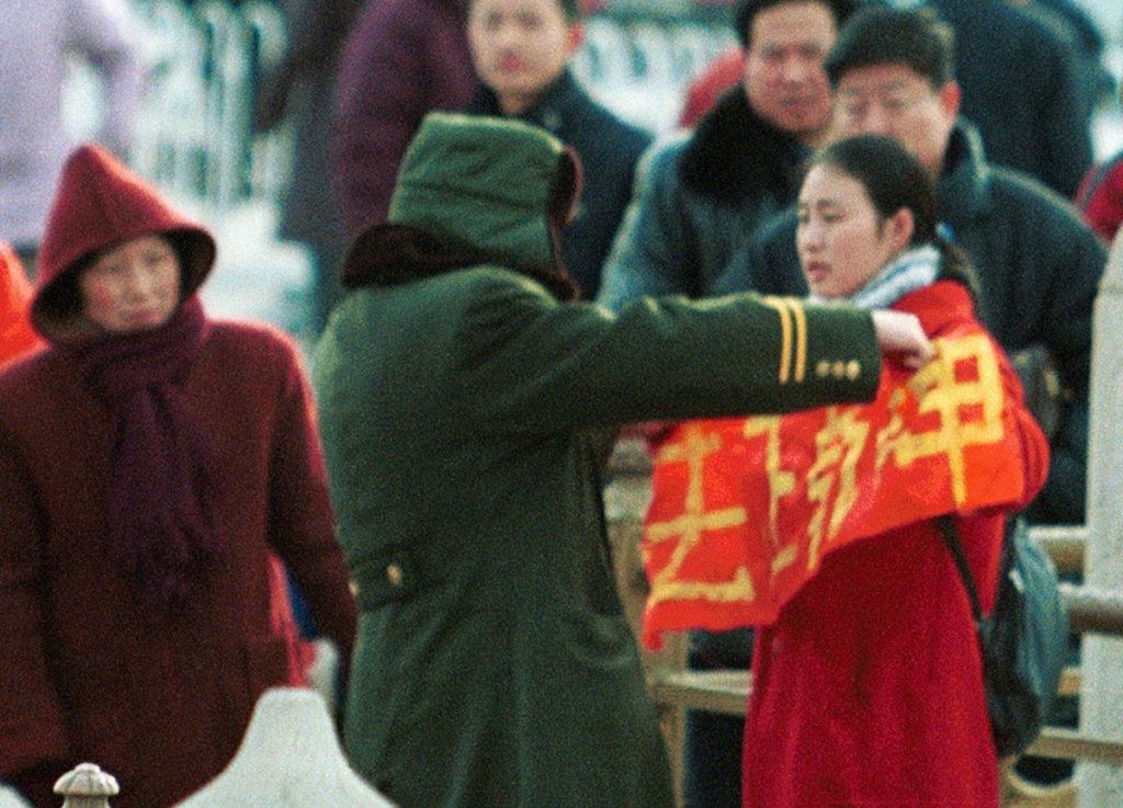 Một phụ nữ cầm biểu ngữ phản đối cuộc đàn áp Pháp Luân Công bị cảnh sát bắt giữ tại Cổng Thiên An Môn, Bắc Kinh, vào ngày 25/01/2001. (Ảnh: AP Photo/Greg Baker)