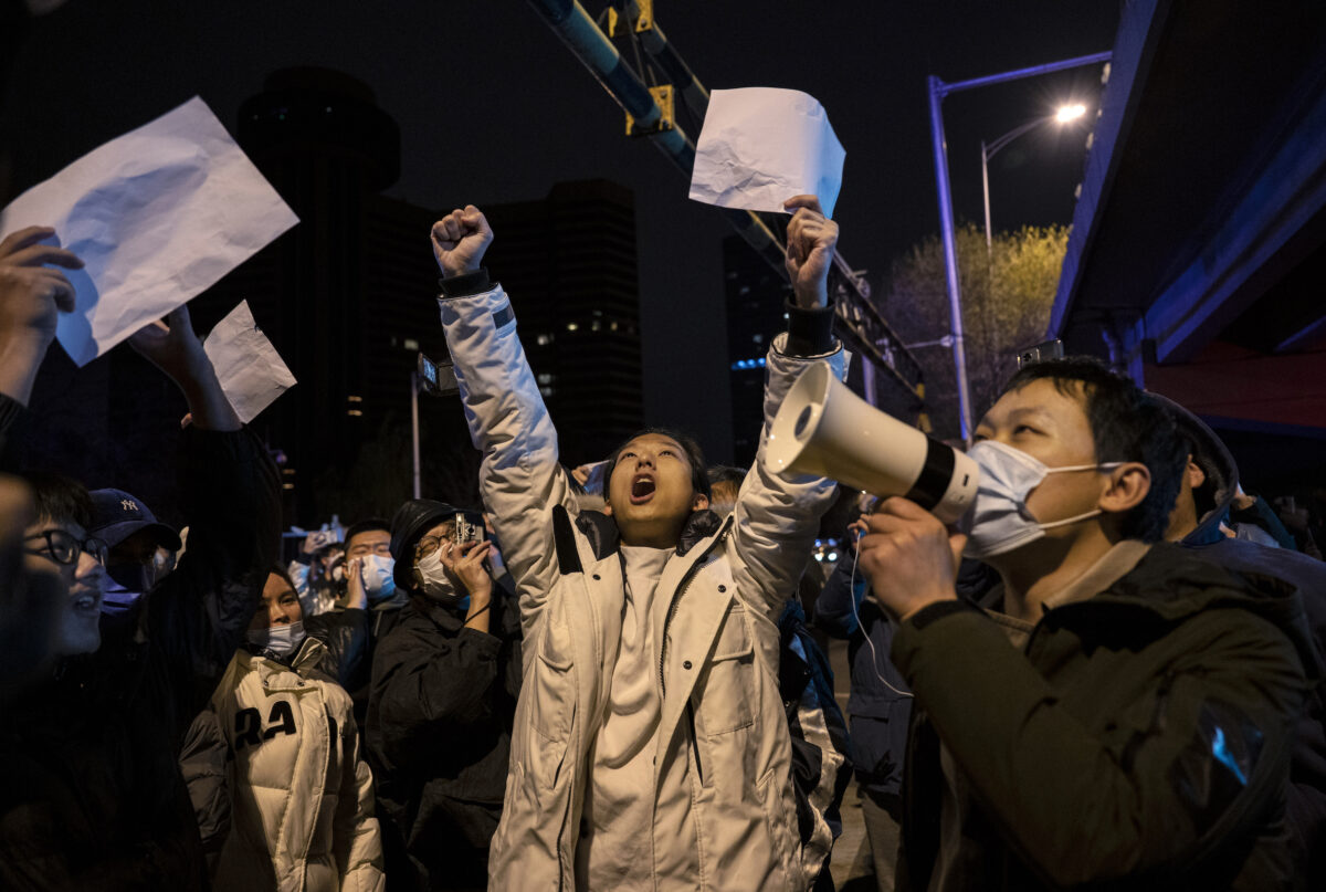 Người biểu tình hô vang khẩu hiệu trong cuộc biểu tình phản đối các biện pháp phòng dịch COVID nghiêm ngặt của Đảng Cộng sản Trung Quốc tại Bắc Kinh hôm 28/11/2022. (Ảnh: Kevin Frayer/Getty Images)