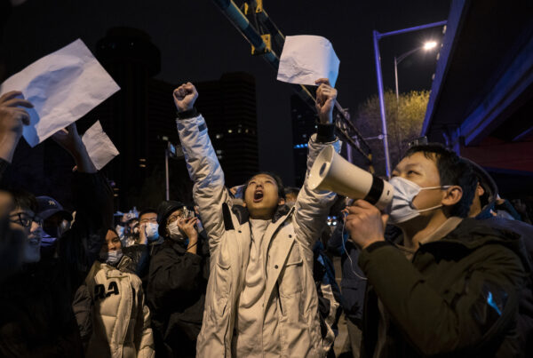 Những người biểu tình hô lớn các khẩu hiệu trong một cuộc biểu tình phản đối các biện pháp hà khắc nhằm ngăn chặn COVID của Đảng Cộng sản Trung Quốc tại Bắc Kinh, Trung Quốc, hôm 28/11/2022. (Ảnh: Kevin Frayer/Getty Images)