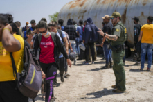 Một nhân viên Tuần tra Biên giới sắp xếp một nhóm lớn những người nhập cư bất hợp pháp gần Eagle Pass, Texas, hôm 20/05/2022. (Ảnh: Charlotte Cuthbertson/The Epoch Times)