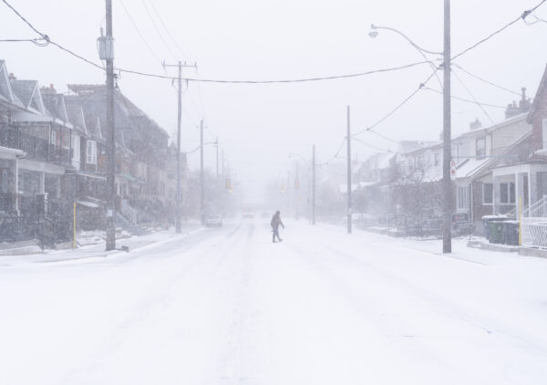 Một người đàn ông băng qua đường trong cơn bão tuyết ở Toronto hôm 23/12/2022. Cảnh báo bão mùa đông được áp dụng cho hầu hết miền nam Ontario. (Ảnh: Arlyn McAdorey/The Canada Press)