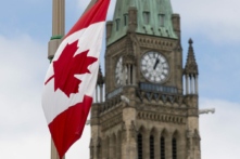 Quốc kỳ Canada treo trên một cột đèn trên con đường phía trước tòa nhà Quốc hội ở Ottawa trước Ngày Quốc khánh Canada vào ngày 30/06/2020. (Ảnh: The Canadian Press/Adrian Wyld)