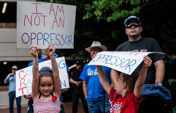 Mọi người giơ cao các tấm bảng trong cuộc biểu tình phản đối thuyết chủng tộc trọng yếu (CRT) đang được giảng dạy trong các trường học tại trung tâm Chính phủ Quận Loudoun ở Leesburg, Virginia, hôm 12/06/2021. (Ảnh: Andrew Caballero-Reynolds/AFP qua Getty Images)