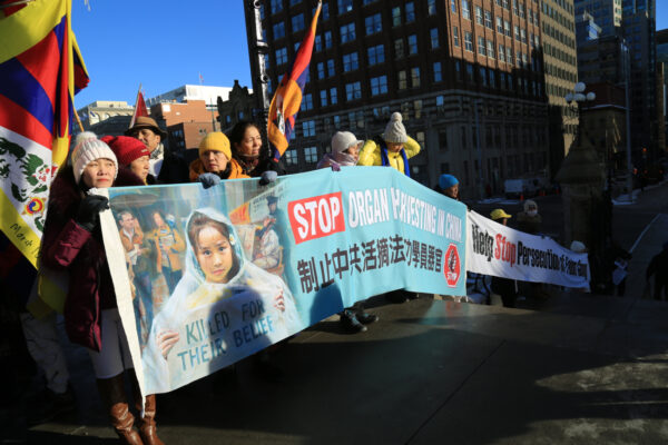 Những học viên của môn tu luyện tinh thần Pháp Luân Công và những người biểu tình Tây Tạng giương cờ và biểu ngữ tại một cuộc tập hợp trước Khu phía Tây trên Đồi Quốc hội để ủng hộ dự luật cấm thu hoạch nội tạng cưỡng bức, tại Ottawa hôm 14/12/2022. (Ảnh: Jian Ren/The Epoch Times)