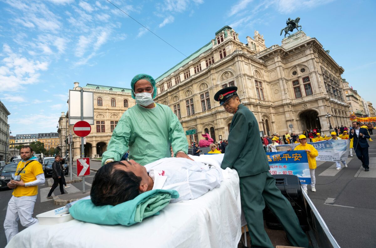 Các học viên Pháp Luân Công ở Vienna, Áo, tái hiện lại cảnh thu hoạch nội tạng của các học viên bị cầm tù ở Trung Quốc trong một cuộc biểu tình phản đối việc nhập cảng nội tạng người từ Trung Quốc sang Áo, vào ngày 01/10/2018. (Ảnh: Joe Klamar/AFP qua Getty Images)
