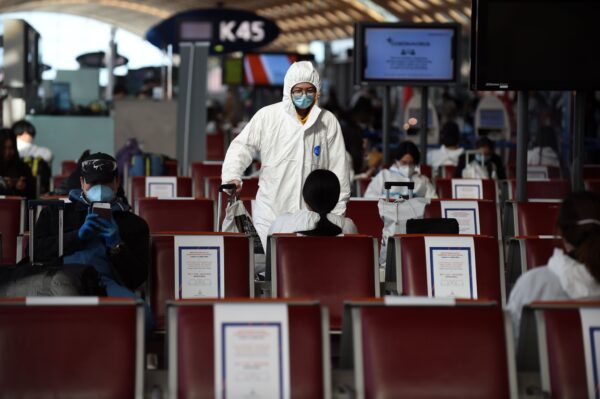 Hành khách mặc quần áo bảo hộ chờ trước khi lên chuyến bay của hãng hàng không China Southern Airlines đến Quảng Châu tại Phi trường Paris Charles de Gaulle vào ngày 12/05/2020. (Ảnh: Eric Piermont/AFP qua Getty Images)