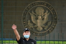 Một nhân viên bảo vệ Trung Quốc ra hiệu bên ngoài đại sứ quán Hoa Kỳ ở Bắc Kinh hôm 12/09/2020. (Ảnh: Greg Baker/AFP qua Getty Images)