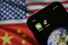 Một chiếc điện thoại di động đang hiển thị logo của các ứng dụng Trung Quốc WeChat và TikTok trước màn hình hiển thị lá cờ của Hoa Kỳ và Trung Quốc trên một trang web trên internet, ở Bắc Kinh, hôm 22/09/2020. (Ảnh: Kevin Frayer/Getty Images)