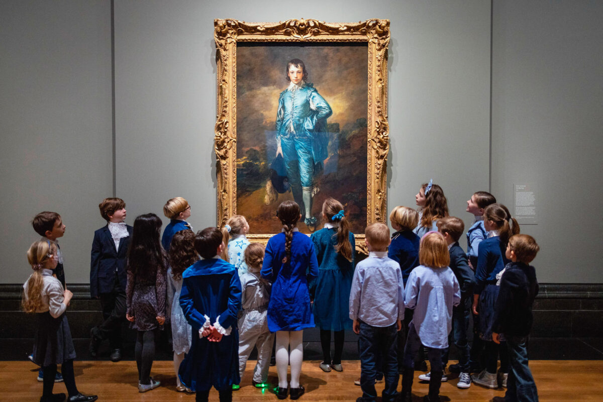 Trẻ em xem tác phẩm “The Blue Boy” của nghệ sĩ người Anh Thomas Gainsborough tại Phòng trưng bày Quốc gia ở London hôm 24/01/2022. Bức tranh được trưng bày ở Vương quốc Anh lần đầu tiên sau 100 năm. (Ảnh: Tolga Akmen/AFP qua Getty Images)