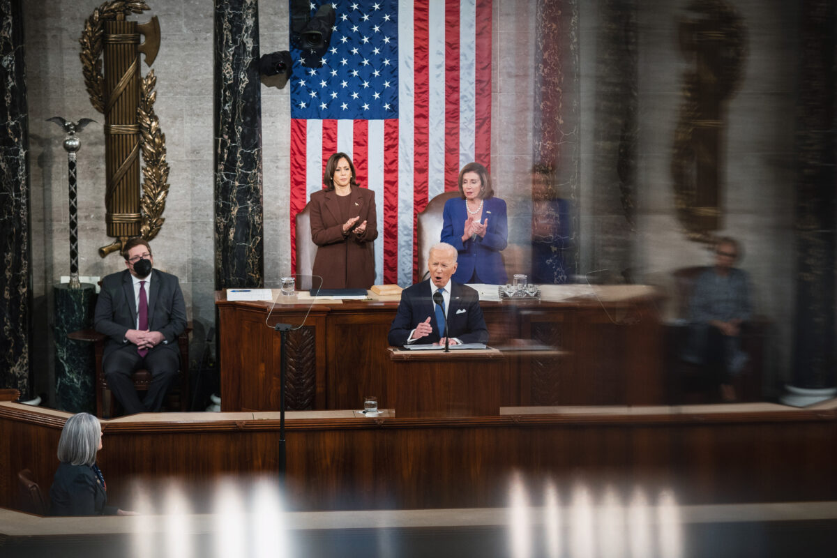 Tổng thống Joe Biden đọc Thông điệp Liên bang chính thức đầu tiên của mình tại Điện Capitol Hoa Kỳ khi Phó Tổng thống Kamala Harris và Chủ tịch Hạ viện Nancy Pelosi vỗ tay sau lưng ông, hôm 01/03/2022. (Ảnh: Sarahbeth Maney-Pool/Getty Images)