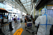 Du khách làm thủ tục trước khi khởi hành tại phi trường Phượng Hoàng ở Tam Á trong bối cảnh thành phố nghỉ dưỡng Tam Á này bị COVID tấn công khiến khách du lịch bị mắc kẹt trên đảo Hải Nam, Trung Quốc hôm 09/08/2022. (Ảnh: STR/AFP qua Getty Images)