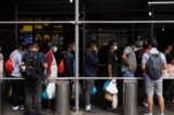 Một nhóm người di cư từ Texas xếp hàng bên ngoài Bến xe buýt Port Authority để nhận trợ giúp nhân đạo ở New York hôm 10/08/2022. (Ảnh: Yuki Iwamura/AFP qua Getty Images)