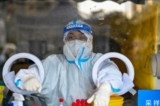 Một nhân viên y tế chờ người dân lấy mẫu bệnh phẩm để xét nghiệm COVID-19 tại Thượng Hải hôm 19/12/2022. (Ảnh: Hector Retamal/AFP qua Getty Images)