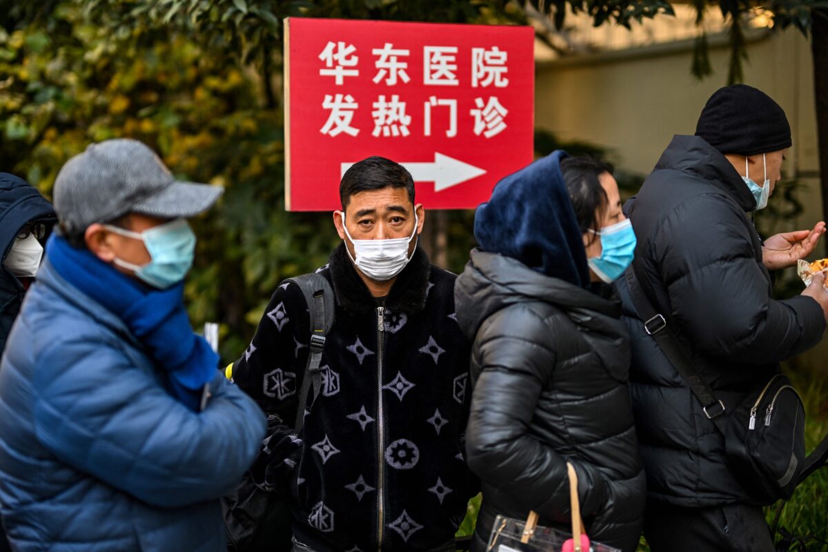 Mọi người xếp hàng chờ bên ngoài phòng khám sốt tại Bệnh viện Hoa Đông ở Thượng Hải hôm 19/12/2022. (Ảnh: Hector Retamal/AFP qua Getty Images)