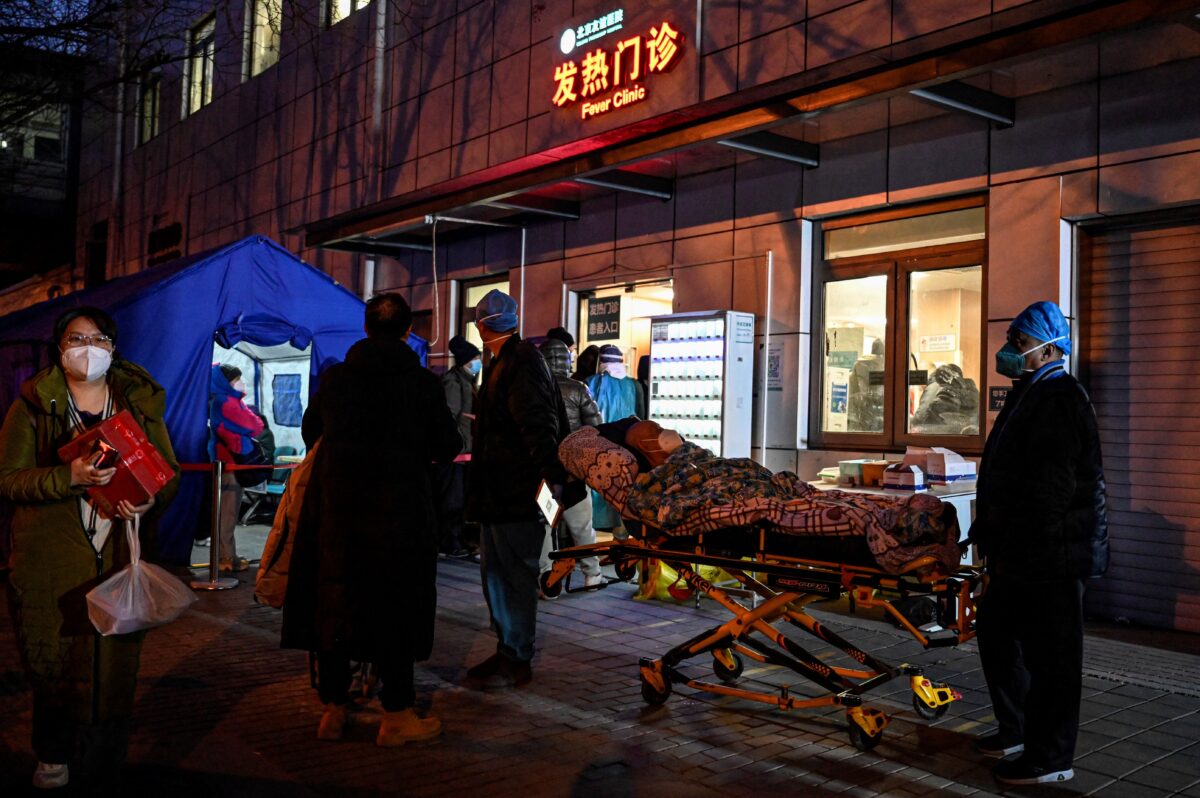Nhân viên y tế cấp cứu vận chuyển một bệnh nhân đến phòng khám sốt tại một bệnh viện trong bối cảnh đại dịch Covid-19 ở Bắc Kinh hôm 21/12/2022. (Ảnh: Jade Gao/AFP qua Getty Images)