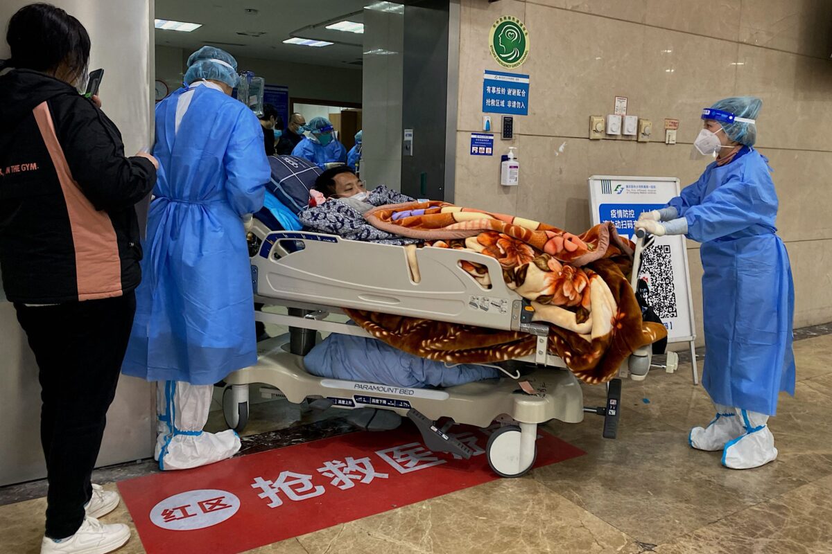 Nhân viên y tế di chuyển một bệnh nhân COVID-19 trên cáng trong khu cấp cứu của Bệnh viện Liên kết Đầu tiên của Đại học Y khoa Trùng Khánh ở Trùng Khánh, Trung Quốc, hôm 22/12/2022. (Ảnh: Noel Celis/AFP qua Getty Images)