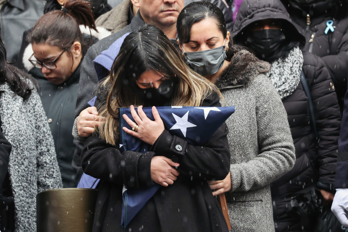 Cô Dominique Rivera, vợ của anh Jason Rivera, cảnh sát thuộc Sở Cảnh sát New York, ôm lá cờ từ quan tài trong lễ tang của anh tại Nhà thờ St. Patrick ở New York, hôm 28/01/2022. (Ảnh: Spencer Platt/Getty Images)