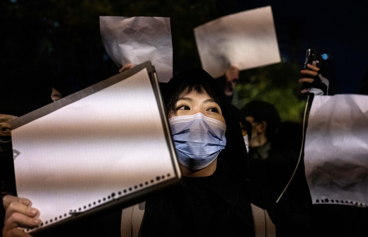 Người biểu tình giơ cao một tờ giấy trắng để tránh bị kiểm duyệt khi họ tuần hành trong một cuộc biểu tình phản đối các biện pháp zero COVID nghiêm ngặt của chính quyền Trung Quốc tại Bắc Kinh hôm 27/11/2022. (Ảnh: Kevin Frayer/Getty Images)