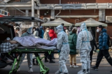 Nhân viên y tế mặc đồ bảo hộ khi họ đang khiêng một bệnh nhân nằm trên cáng tại một phòng khám sốt ở Bắc Kinh, Trung Quốc, hôm 09/12/2022. (Ảnh: Kevin Frayer/Getty Images)