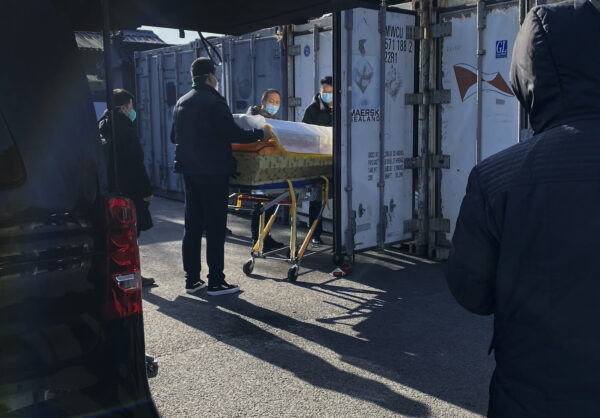 Một chiếc quan tài được đưa từ xe tang vào container đông lạnh bảo quản thi thể tại nhà tang lễ và trung tâm hỏa táng Đông Giao, một trong số những nơi chuyên giải quyết các ca nhiễm COVID-19 tại thành phố Bắc Kinh, Trung Quốc, hôm 18/12/2022. (Ảnh: Getty Images)
