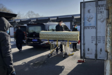 Một linh cữu được hạ từ ​​xe tang và chuyển vào một container bảo quản lạnh tại nhà tang lễ và lò hỏa táng Đông Giao, một trong những nhà hỏa táng trong thành phố được chỉ định để giải quyết các ca nhiễm COVID-19, tại Bắc Kinh hôm 18/12/2022. (Ảnh: Getty Images)