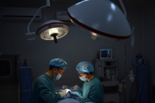 Bức ảnh được chụp vào ngày 09/08/2013 này cho thấy một bác sĩ phẫu thuật thẩm mỹ (Trái) đang thực hiện ca phẫu thuật mũi “đặc biệt” cho một bệnh nhân tại phòng khám của ông ở thành phố Trùng Khánh, phía tây nam Trung Quốc. (Ảnh: Peter Parks/AFP/Getty Images)