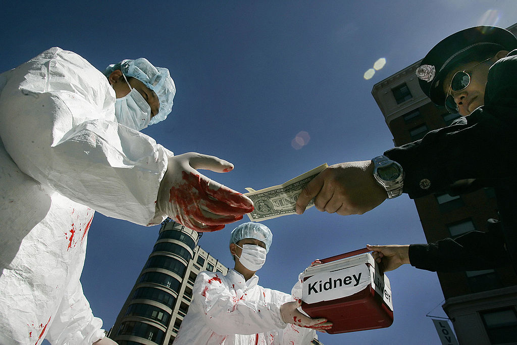 Các học viên Pháp Luân Công tái hiện lại hành động trả tiền mua nội tạng người bất hợp pháp trong cuộc biểu tình ở Hoa Thịnh Đốn vào ngày 19/04/2006, nhân chuyến thăm Hoa Kỳ của lãnh đạo Trung Quốc Hồ Cẩm Đào. (Ảnh: Jim Watson/AFP qua Getty Images)