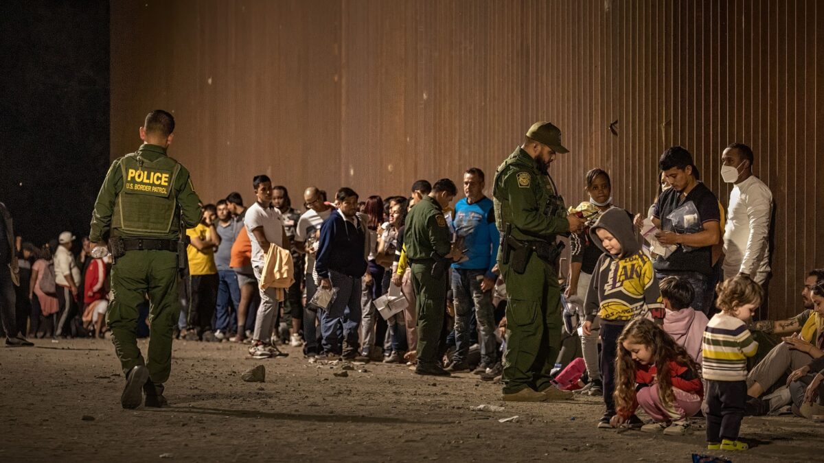 Các nhân viên Lực lượng Tuần tra Biên giới Hoa Kỳ kiểm tra giấy tờ tùy thân của những người nhập cư khi họ chờ được giải quyết sau khi băng qua biên giới từ Mexico ở Yuma, Arizona, hôm 22/06/2022. (Ảnh: Qian Weizhong/VCG/Getty Images)