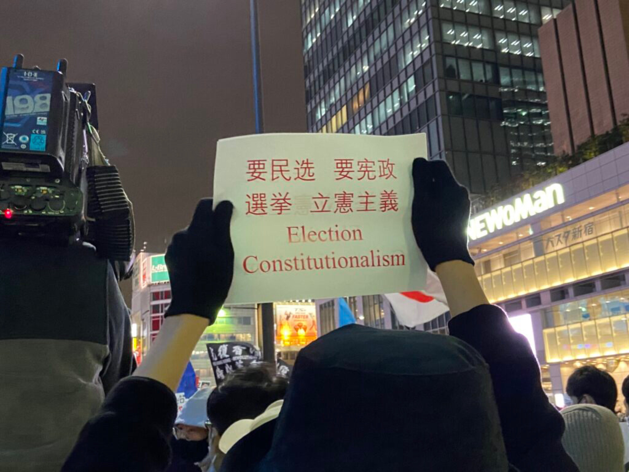 Người biểu tình ở Nhật Bản giương cao biểu ngữ đòi bầu cử công bằng và chính phủ hợp hiến ở Trung Quốc. (Ảnh: The Epoch Times)