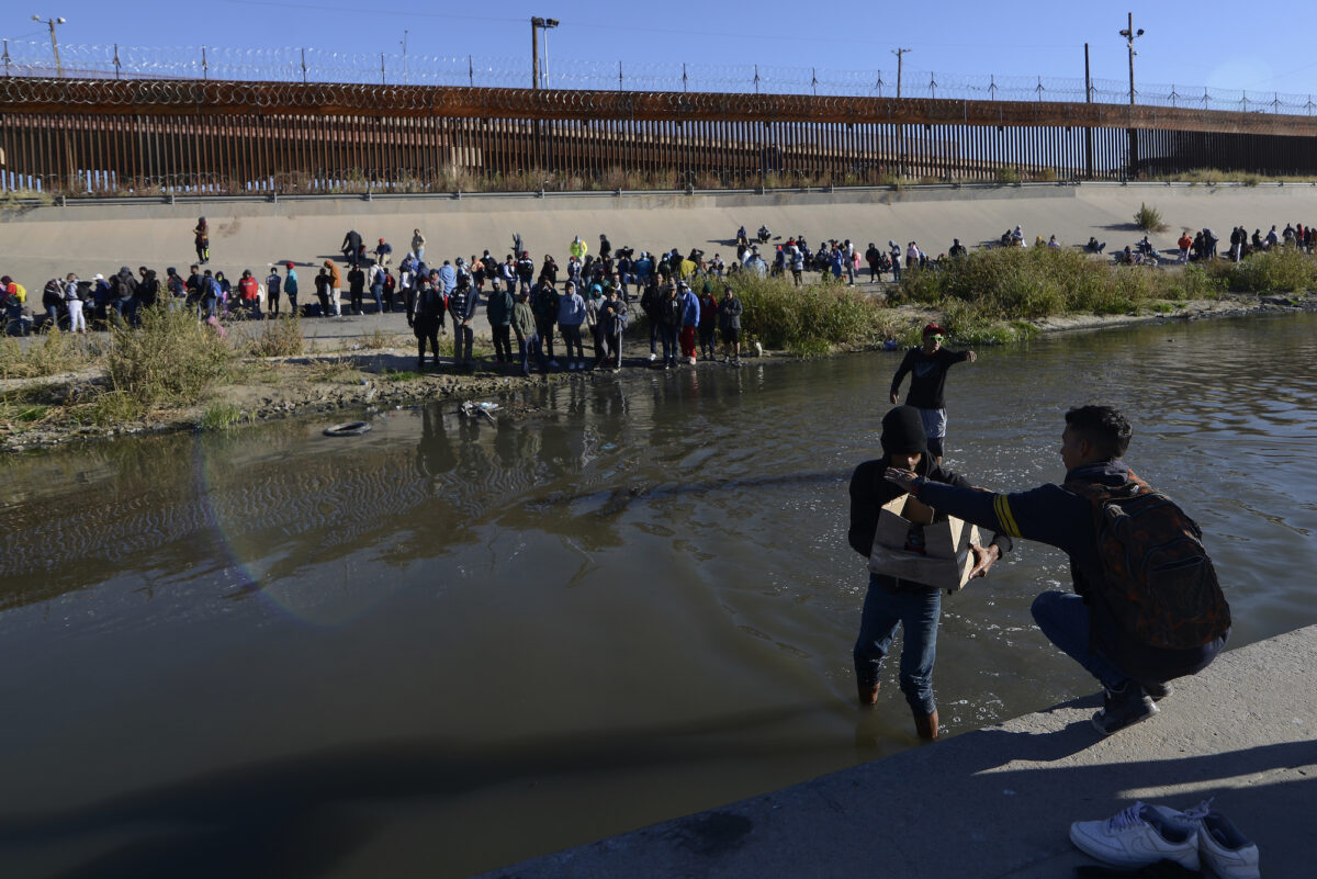 Những người nhập cư bất hợp pháp vượt qua biên giới Mexico-Hoa Kỳ để đầu hàng các nhân viên của Lực lượng Tuần tra Biên giới Hoa Kỳ, tại Ciudad Juarez, Mexico, hôm 12/12/2022. (Ảnh AP Photo/Christian Chavez)