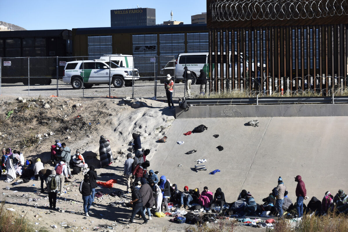 Những người nhập cư bất hợp pháp chờ qua biên giới Hoa Kỳ-Mexico từ Ciudad Juárez, bên cạnh các phương tiện của Lực lượng Tuần tra Biên giới Hoa Kỳ ở El Paso, Texas, Thứ Tư, nhôm 14/12/2022. (Ảnh AP Photo/Christian Chavez)