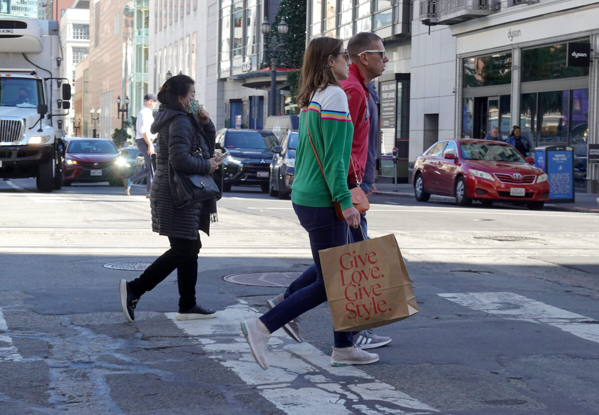 Một người đi bộ xách túi mua sắm khi băng qua đường ở San Francisco hôm 16/11/2022. (Ảnh: Justin Sullivan/Getty Images)