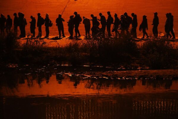 Những người nhập cư bất hợp pháp đi trong một đoàn lữ hành hơn một ngàn người băng qua sông Rio Grande để vào Hoa Kỳ, ở Ciudad Juarez, tiểu bang Chihuahua, Mexico, hôm 11/12/2022. (Ảnh: Herika Martinez/AFP via Getty Images)