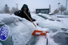 Một công nhân dọn tuyết cho xe hơi tại bãi xe hơi đã qua sử dụng Bereg sau một cơn bão trong đêm ở Orem, Utah, hôm 13/12/2022. (Ảnh: George Frey/AFP qua Getty Images)