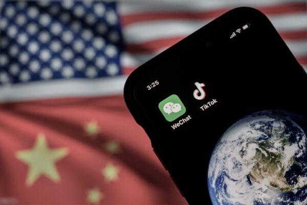Một chiếc điện thoại di động đang hiển thị logo của các ứng dụng Trung Quốc WeChat và TikTok trước màn hình hiển thị các quốc kỳ của Hoa Kỳ và Trung Quốc trên một trang Internet, ở Bắc Kinh, vào ngày 22/09/2020. (Ảnh: Kevin Frayer/Getty Images) 