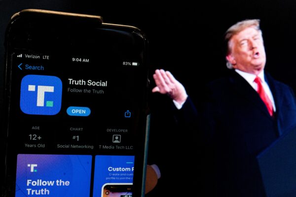 Hình ảnh cựu Tổng thống Donald Trump bên cạnh màn hình điện thoại đang hiển thị ứng dụng Truth Social ở Hoa Thịnh Đốn hôm 21/2/2022. (Ảnh: Stefani Reynolds/AFP qua Getty Images)