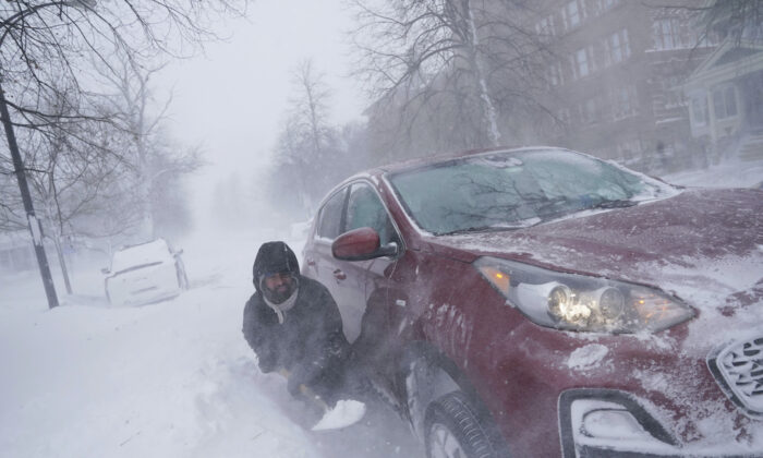 Anh Gamaliel Vega cố gắng đào lớp tuyết vây quanh chiếc xe của mình trên Đại lộ Lafayette sau khi anh bị mắc kẹt trong đống tuyết cách nhà anh một dãy nhà. Anh làm vậy để mau chóng tới giải cứu người anh họ của mình, người đang phải sống trong cảnh không có điện và hệ thống sưởi ấm cùng với một người con ở ngôi nhà phía bên kia thị trấn trong một trận bão tuyết ở Buffalo, New York, hôm 24/12/2022. (Ảnh: Derek Gee/The Buffalo News qua AP)